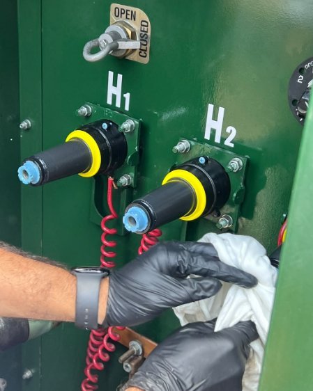 Técnico con guantes limpiando las terminales de media tensión del transformador
